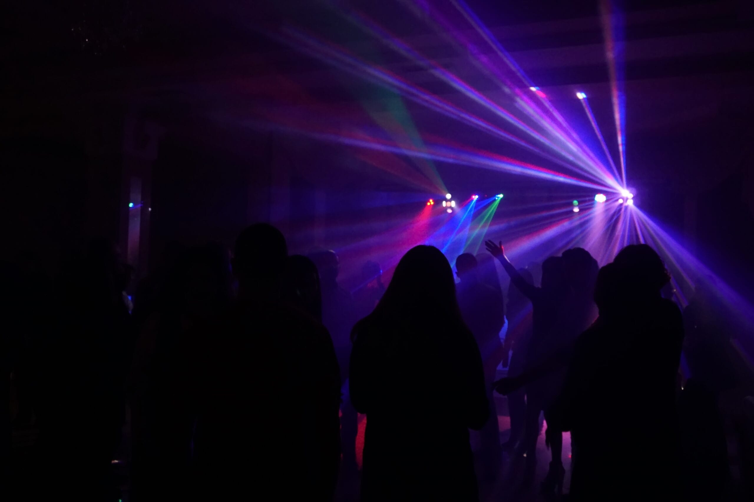 Crowd of people dancing under disco laser light Crowd of people dancing under disco laser light